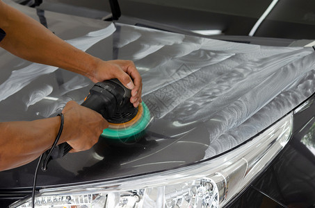 在职的服务工人负责打磨涂层汽车擦面的男子在车面后会帮助消除车面表的污染物在擦车面之后将发光图片