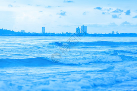 柔软的旅游雨暴风天过后一片宁静的蓝海一个度假镇在背景上模糊不清关注波浪假日度概念图片