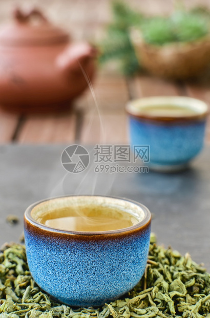 箱蓝茶碗中的热青石桌蒸汽从碗中冒出来茶叶在杯子旁边的树叶菜单最小图片