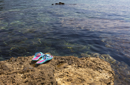 礁石上的塑料拖鞋图片
