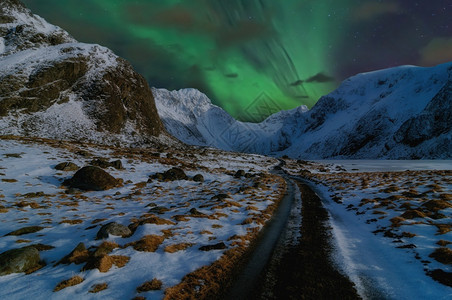 极海岸通向高山的美丽道路由北光或AuroraBorealis挪威冬季美丽的山地风景挪威斯堪的纳维亚冬季和挪威斯堪的纳维亚暮图片