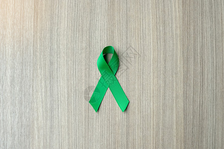 肝炎木制的病人提高肝癌意识关于木背景的绿色丝带以支持人们生活和疾病保健及世界癌症日概念健康保和世界癌症日概念图片