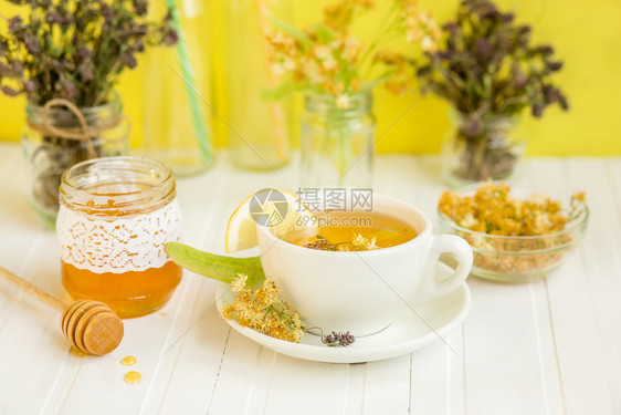 一杯热茶在木板上打麻布和茶叶种植园背景上打麻布一杯热茶在木桌上打爆红茶草本植物乡村春天图片