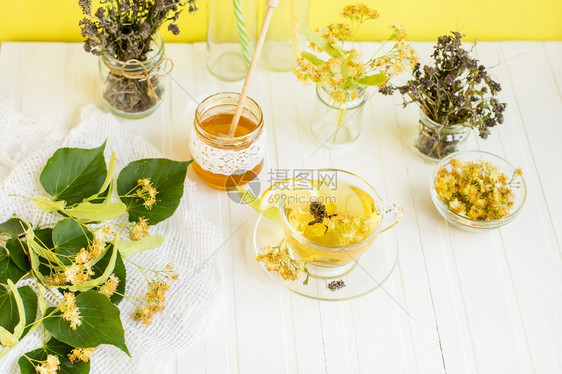 蜜糖一杯热茶在木板上打麻布和茶叶种植园背景上打麻布一杯热茶在木桌上打爆红茶日出云图片