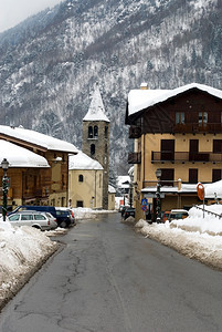 钟楼明尼斯冬天暴风雪过后在意大利高山村的一条狭窄街道上图片