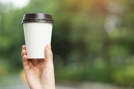 人类马克杯早晨举着咖啡纸杯的男子手背景图片