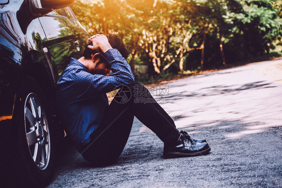 持智能电话和坐在停路边的汽车上失望男子街道司机事故图片