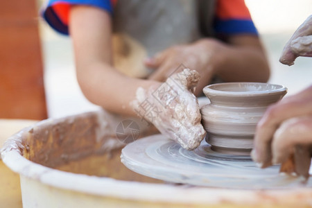 作坊年轻陶匠的手在圆圈上制造一个土罐子波特拇指图片