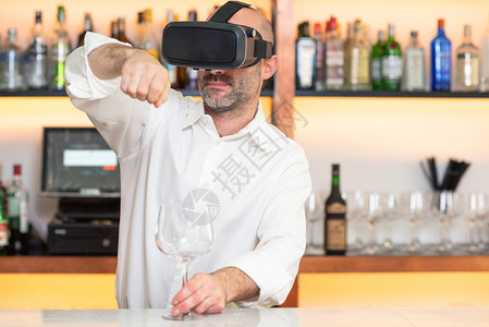 酒吧男女未来派酒保学徒培训与虚拟现实老师一起提供鸡尾酒学徒习如何使用虚拟现实眼镜准备鸡尾酒保学徒培训与虚拟现实老师一起提供鸡尾酒学徒习如背景