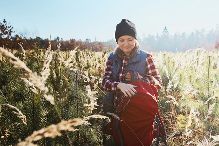 远足运动享受山上之旅的年轻女子站立在田径上与自然相亲渡暑假背着包徒步穿越高草地在山中漫步健康图片