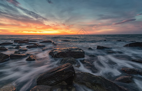 在日出期间海景与岩石相伴的海景震撼自然上日出在黑岸水旅行早晨图片