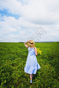跳过戴帽子的漂亮女孩有一束鲜花别致的绿地戴帽子漂亮女孩别致的绿地幸福美丽图片