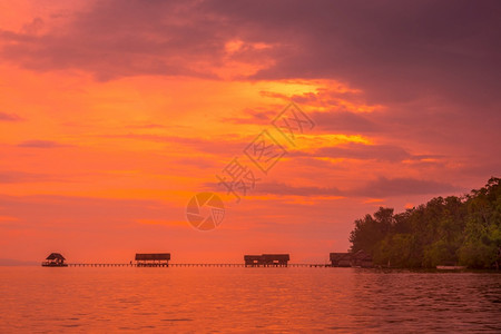 印度尼西亚该岛拉贾阿姆帕特群岛海岸有一个船码头供只在热带岛屿上停靠海洋平静和橙色日落冷的黄昏水色图片