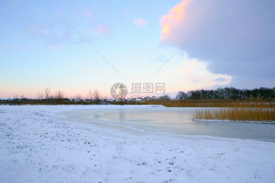 蒙反射荷兰冬季景观美丽的彩色日落天空和新鲜的白雪美丽自然背景溪流荷兰的冬季景观美丽的自然背景多雾路段图片