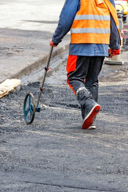 道路服务工人测量途用一个计量车轮衡公路距离确定铺垂直图象所需的沥青量复制空间A路服务工人用电子计量车对工作场所进行计量A路服务工图片