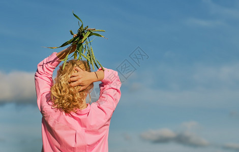 或者一种生长美丽的女人与她站在一起架子上双手小麦耳朵的头上用云彩蓝天有选择地聚焦于复制空间标语或背景思想图片