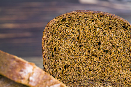 健康小麦鲜烤黑面包香热在家里或工业生产中被切成碎片新鲜烤黑面包暗的图片