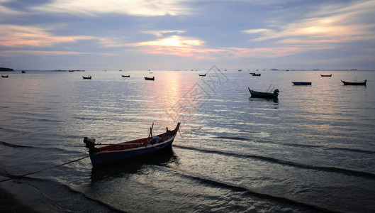 夏天黑暗的橙许多渔船在泰国黄昏的海面上暗淡画图片