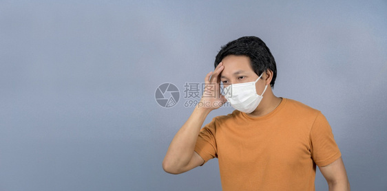 曼谷抗菌戴面罩的亚洲男子身穿外科手术面具头痛并担心蓝底科罗纳流行共生19年爆发社会不和责任保健防范概念停留图片