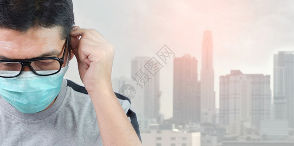 环境尘土飞扬健康身戴眼镜的紧亚洲男子俯首仰面戴着保护具在传播2019年科罗纳的背景中城市风模糊不清图片