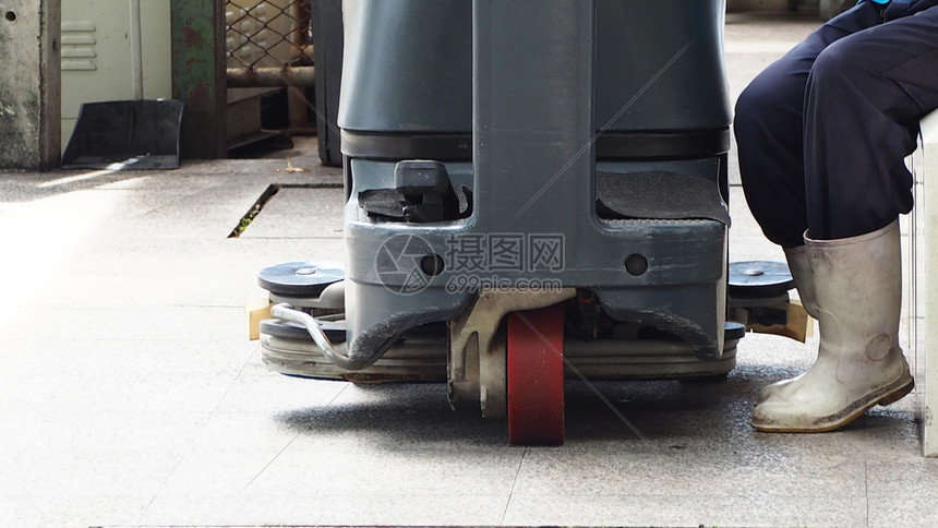 车轮用于清洁和保养的工业用地板洗涤器冲工用地板人穿白色水井靴在用洗涤机管理服务概念清洗地板后可以留下来商业涌动图片
