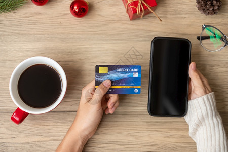 网络在12月圣诞快乐夜12月季节黑星期五销售新年和节假日概念期间手持信用卡于在线购买智能手机的网上购物为了保持图片