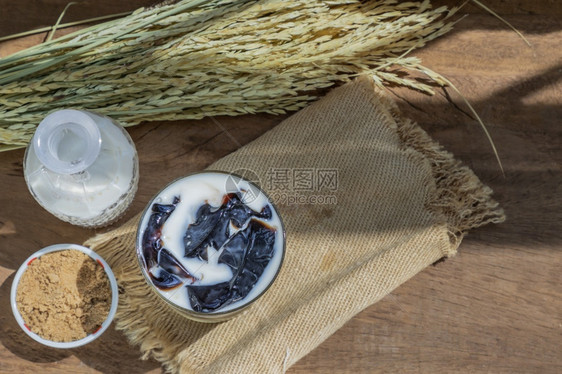 传统的人一种杯新鲜奶草果酱DessertShebalgelatin或果冻黑的木制背景有牛奶和棕色糖图片