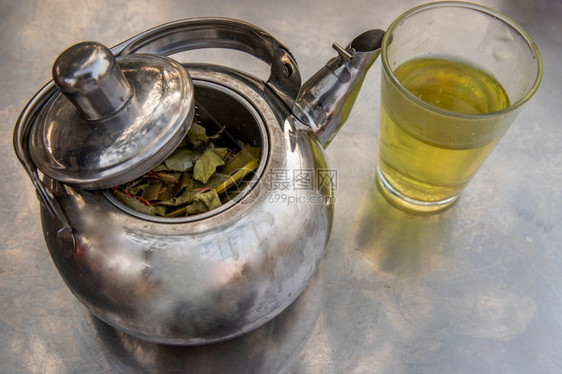 有香味的防锈气茶壶草药在不锈钢板上加一杯热辣草凉茶从顶部看奥布里克图片