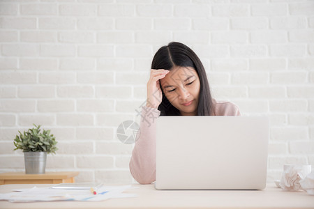 痛亚洲妇女长时间在电脑上工作的压力很大Office综合症概念长期从事计算机工作的亚洲妇女桌子商业图片