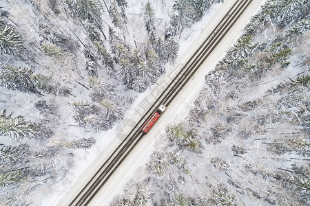 高的寒冷冬季森林中雪覆盖道路空中景象卡车经过运动模糊美丽的图片