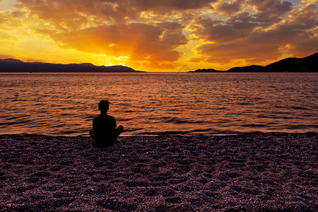 山紫色的希腊洛特拉基州科林斯湾卢特拉基Loutraki照片与影印空间Silhouette的图像片来自一位坐在海边石滩上希腊科林斯图片