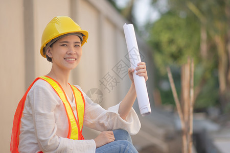 建造在职的妇女工程设计硬帽安全西装持有建筑施工蓝图检查作妇女企业主合作图片