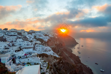 丰富多彩的阳光建筑学希腊桑托里尼岛的OiaSantoriniYachts岛的希腊圣托里尼岛白屋和在希腊圣托里尼岛的日出云月升卡塔背景图片