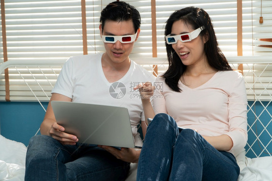 在线的带着3D眼镜快乐的年轻夫妇看着笔记本一起观看电影技术概念为方便婚后幸福而创造科技的概念男家图片