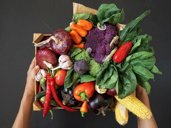 饮食木制的黄瓜黑背景木箱里新鲜蔬菜握着盒子的手收割顶端风景图片