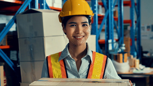 女士亚洲年轻仓库工人在中微笑的肖像物流供应链和仓库业务概念亚洲年轻女仓库工人在中微笑的肖像保持快乐图片