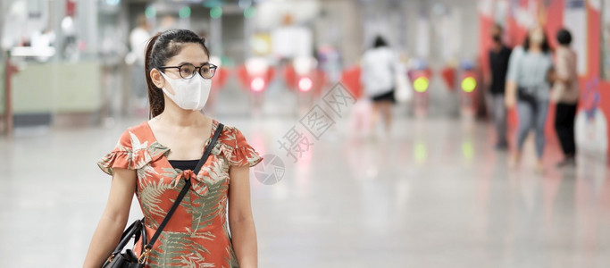 人们身戴外科面地铁里戴口罩预防流感的女性图片