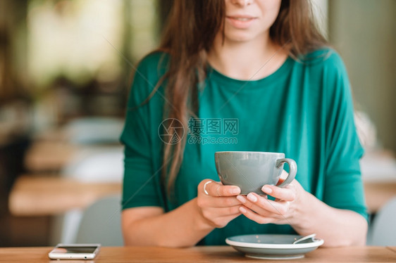 生活学美丽的女孩在户外咖啡厅吃早餐的肖像咖啡手握着美丽的女人在户外咖啡厅吃早餐快乐的年轻城市妇女喝咖啡游客图片