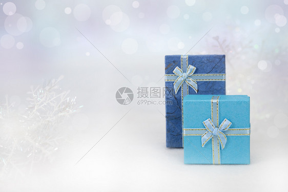 生日惊喜Bokeh背景白皮上的蓝色礼物盒有圣诞快乐或新年季节问候的复制空间AF点选择blurred弓图片