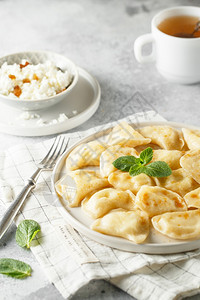 焦糖煮熟的装满干酪俄罗斯乌克兰或波菜瓦雷尼基皮洛吉烟花的土豆糕点图片