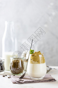 Dalgona咖啡有趋势的Korean喝拿铁咖啡加白木桌面板粉冰子夏天图片