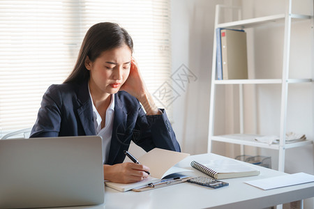 经理桌子笔记本电脑亚洲商业妇女长时间在电脑上工作的压力很大办公室综合症概念长期与计算机打交道的亚洲商业妇女图片