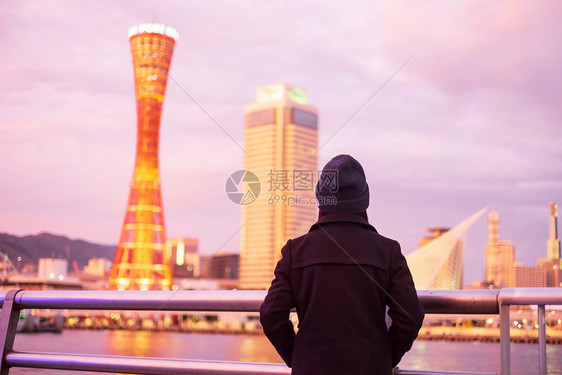 在大阪附近的神户港旅行年轻女快乐亚洲旅行者在日落里程碑处看着美丽的现代建筑在日本兵库县神户市旅游景点很受青春欢迎女士终端靠近图片