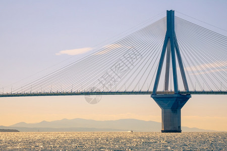 天空夏旅行希腊桥RionAntirionHiltPylon位于科林斯湾的有线滞留桥和阳光明日的有线维持桥和机动船的汽车图片