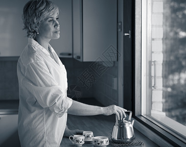 美丽的国内冷静清晨成年女人在厨房喝咖啡阳光从窗外照出来自窗户的阳光图片
