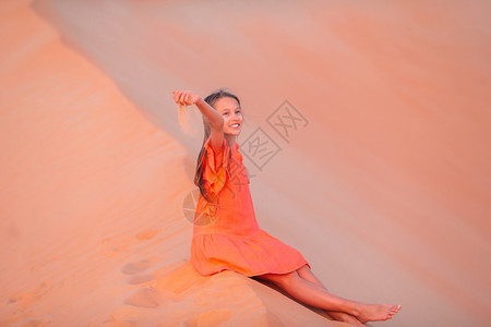 干旱裙子荒芜阿拉伯联合酋长国RubalKhali沙漠的丘中穿着红色连衣裙的漂亮女孩在美丽的沙漠中度假图片