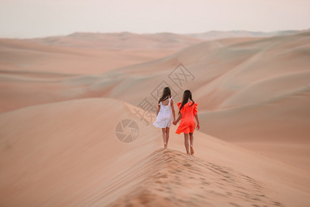 夕阳下沙漠丘上的可爱小女孩阿拉伯联合酋长国鲁卜哈利沙漠丘中的女孩广阔自然扎比图片