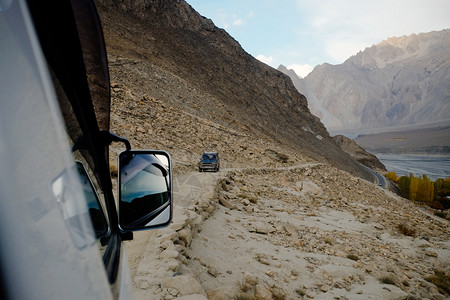 巴基斯坦GojalHunzaGilgilBaltistan的卡拉科姆山脉土路旁驾驶越野车的巴基斯坦当地人的岩石小心图片