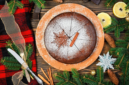 假期传统自制甜点是巧克力蛋糕圣诞饼在黑木桌上装饰着圣诞树枝的黑色木质小餐桌边Kladdkaka粘黏的瑞典派分支机构装饰品图片