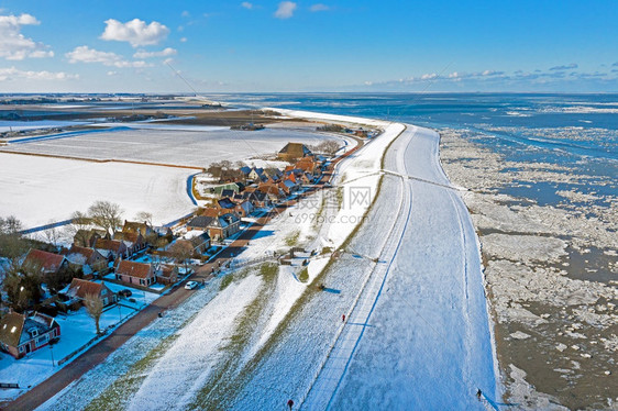 荷兰冬季寒冷的瓦登海从雪地村庄Moddergat起飞的空中机圣诞节自然冬天图片